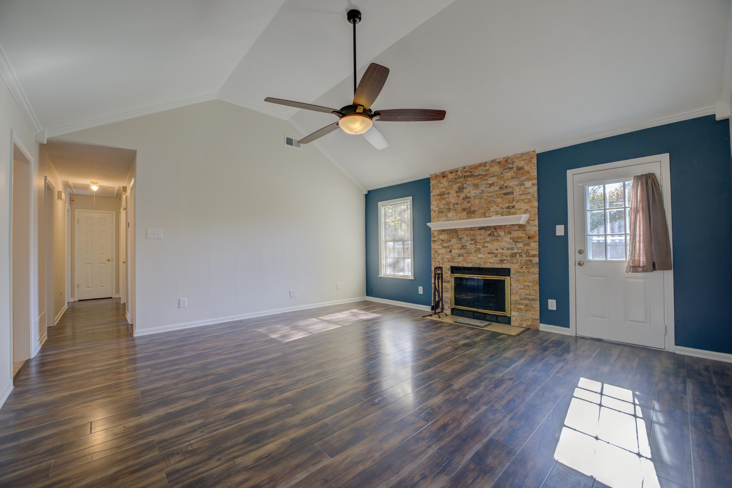 7555 Reese Road Memphis, TN 38133 - Photo 5 of 22 Unfurnished living room with dark hardwood / wood-style flooring, a brick fireplace, ceiling fan, and lofted ceiling