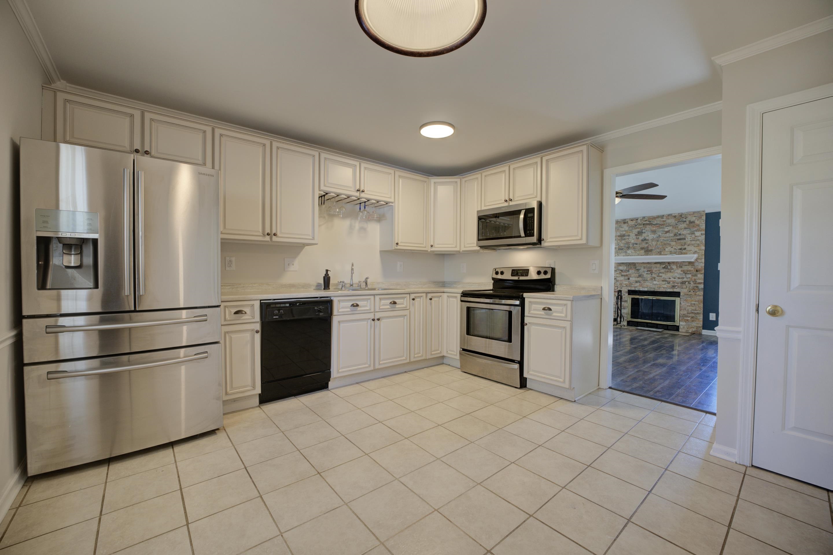 7555 Reese Road Memphis, TN 38133 - Photo 8 of 22 Kitchen featuring appliances with stainless steel finishes, light tile patterned floors, ceiling fan, and ornamental molding