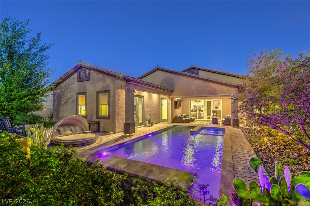 7119 Arabian Ridge Street Las Vegas, NV 89131 - Photo 45 of 73 An illuminated backyard retreat with a shimmering pool beckons for twilight relaxation.