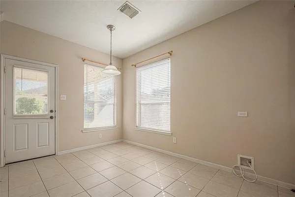 an empty room with windows and chandelier