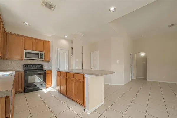 a kitchen with stainless steel appliances a stove a sink and white cabinets