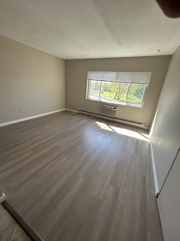 71 Pond Street, Unit 21A Quincy, MA 02169 - Photo 2 of 9 an empty room with wooden floor and windows