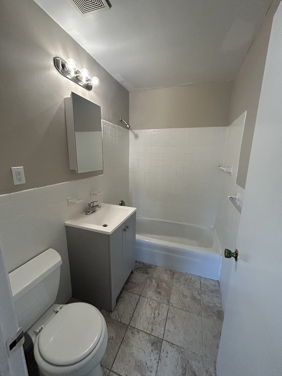 71 Pond Street, Unit 21A Quincy, MA 02169 - Photo 6 of 9 a bathroom with a sink a toilet and shower