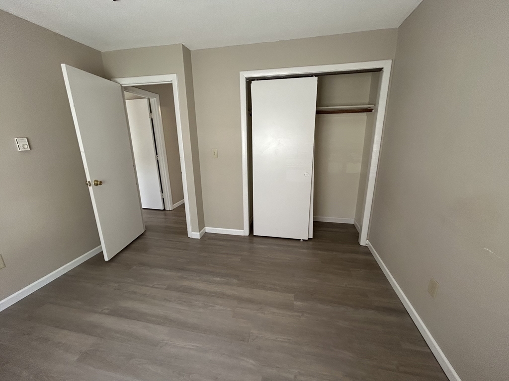 71 Pond Street, Unit 21A Quincy, MA 02169 - Photo 9 of 9 an empty room with wooden door and mirror