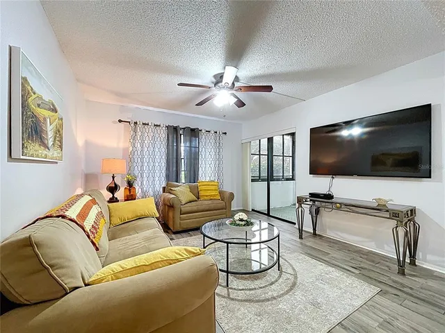 a living room with furniture and a wooden floor