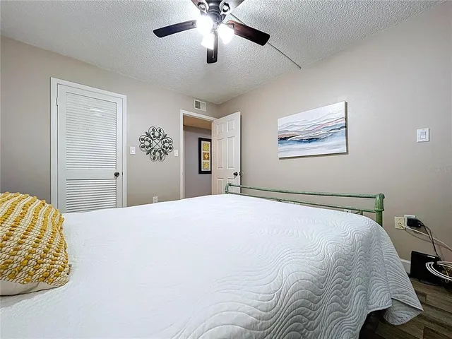 a bedroom with a large bed and a chandelier