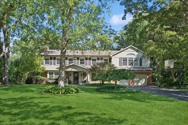 a front view of a house with a yard and trees
