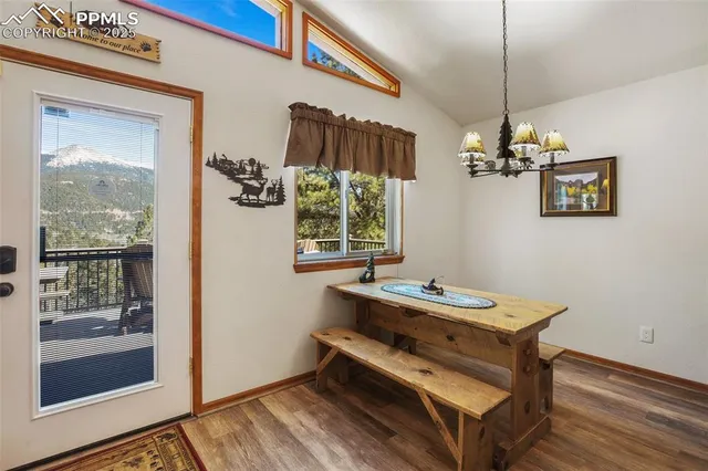 a room with chandelier fan and wooden floor