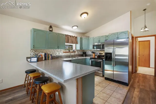 a kitchen with stainless steel appliances granite countertop a sink a stove and a refrigerator