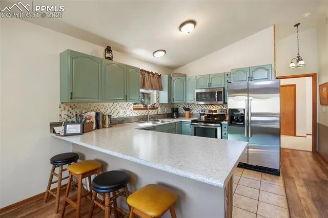 a kitchen with stainless steel appliances granite countertop a sink a stove and a refrigerator