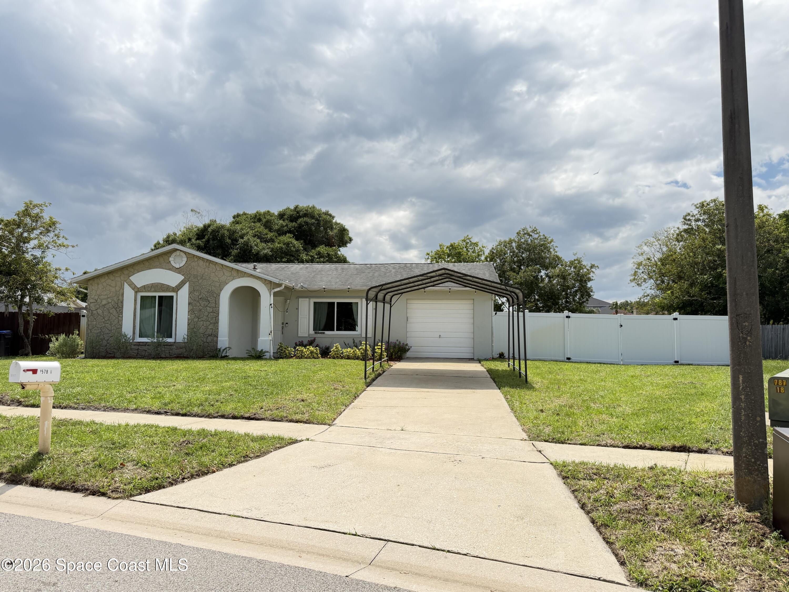 1578 West Powder Horn Road Titusville, FL 32796 - Photo 1 of 22 a front view of a house with a yard