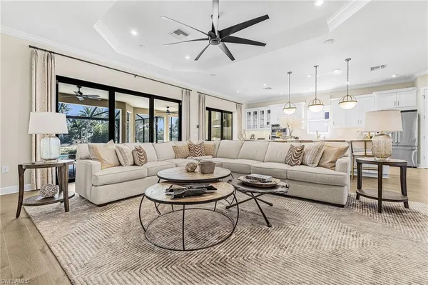 a living room with furniture a ceiling fan and a large window