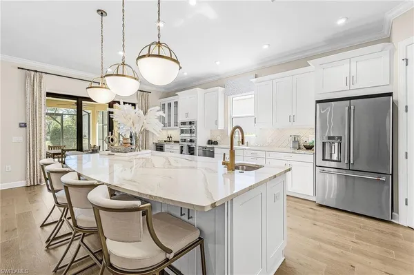 a large kitchen with granite countertop a table chairs stove and refrigerator