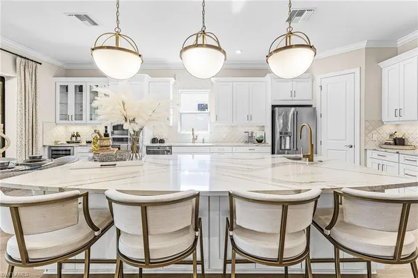a kitchen with stainless steel appliances kitchen island a table and chairs