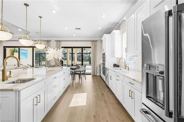 a large white kitchen with a large window and stainless steel appliances