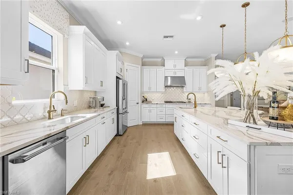 a large white kitchen with granite countertop lots of white appliances