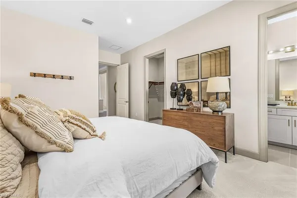 a bedroom with a bed and a large mirror