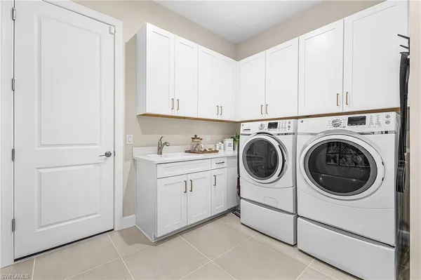 a utility room with sink dryer and washer