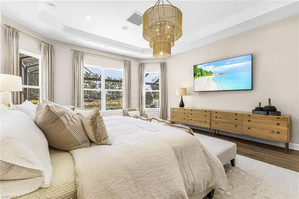 a bedroom with a large bed and a chandelier