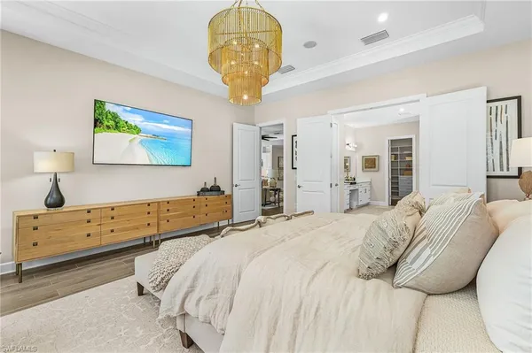a spacious bedroom with a bed and a chandelier
