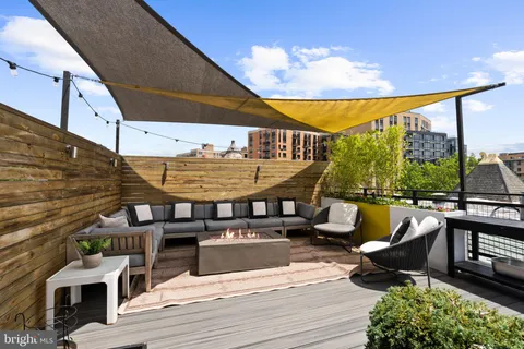 a view of a patio with a dining table and chairs potted plants