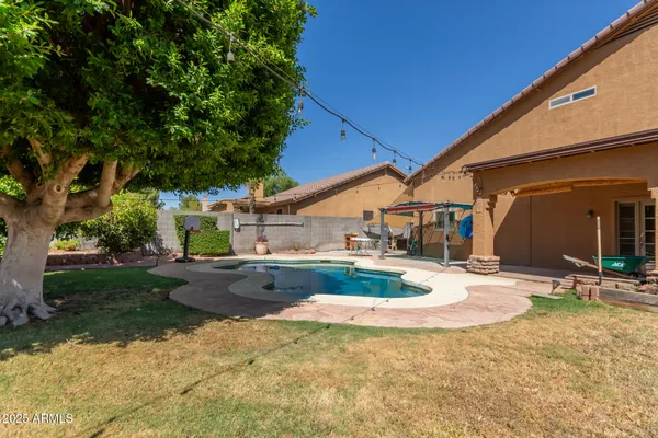 a view of a house with backyard and tree