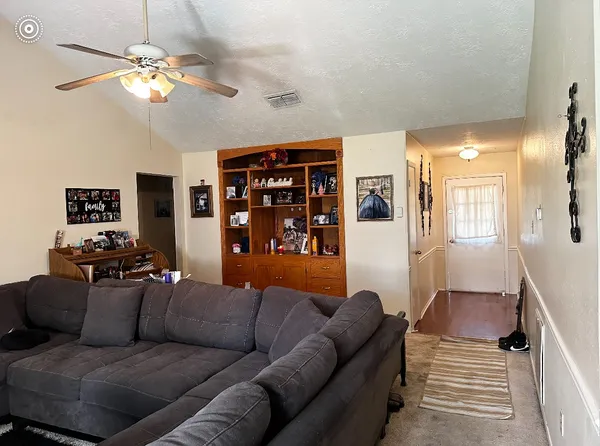 a living room with furniture a ceiling fan and a rug