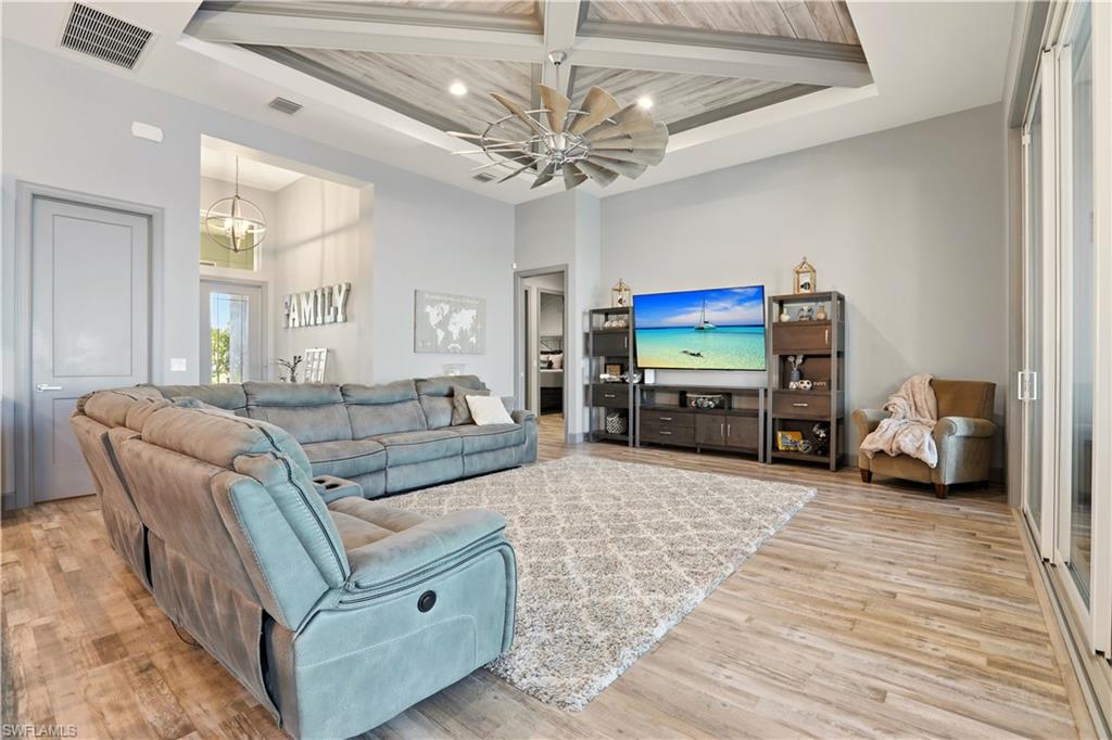 1616 Old Burnt Store Road North Cape Coral, FL 33993 - Photo 12 of 50 Living room with a wood ceiling with exposed beams, a chandelier, recessed lighting, light wood-style floors, and a high ceiling.