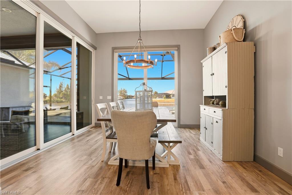 1616 Old Burnt Store Road North Cape Coral, FL 33993 - Photo 17 of 50 Dining space featuring a chandelier and light wood finished floors with Sliding Door to the Pool area and to the covered lanai area.