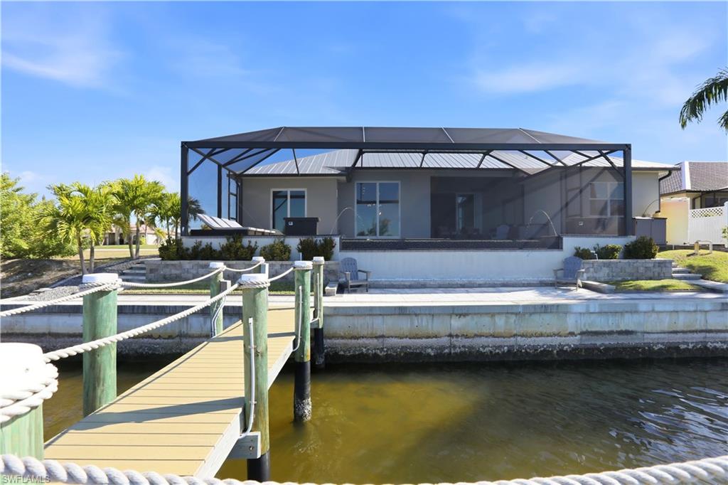 1616 Old Burnt Store Road North Cape Coral, FL 33993 - Photo 24 of 50 Rear view of house featuring concrete seawall and concrete decking.