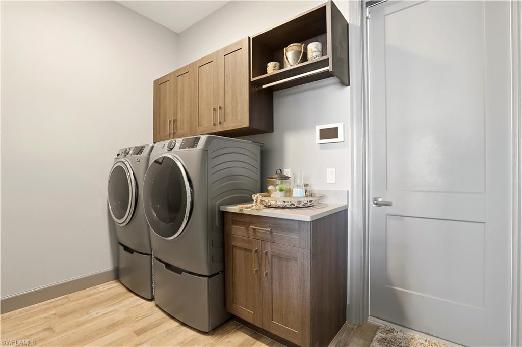 1616 Old Burnt Store Road North Cape Coral, FL 33993 - Photo 37 of 50 Laundry area featuring light wood-style flooring, washer and dryer, and cabinet space