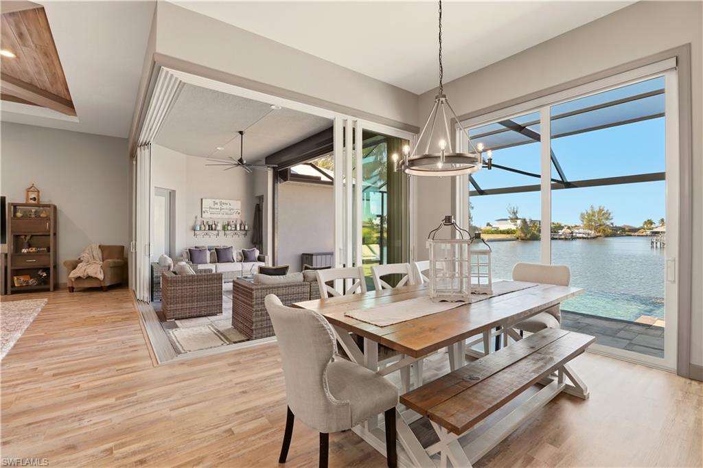 1616 Old Burnt Store Road North Cape Coral, FL 33993 - Photo 38 of 50 Dining space featuring light wood-style floors, ceiling fan, a water view, and a chandelier