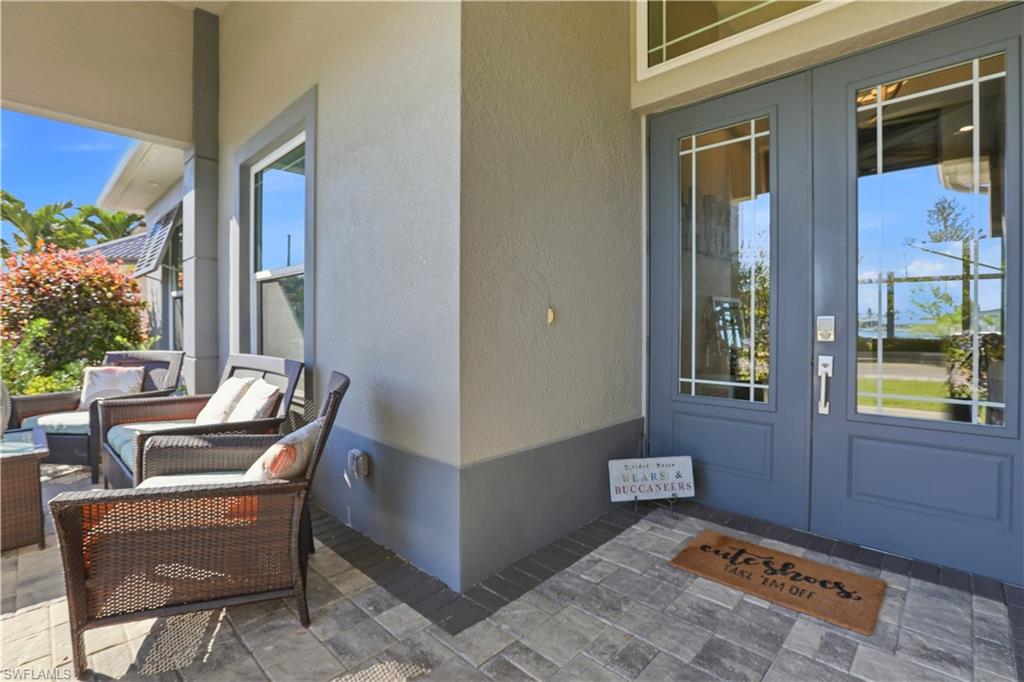 1616 Old Burnt Store Road North Cape Coral, FL 33993 - Photo 7 of 50 Doorway to property with solid french doors, stucco siding, and a comfortable outdoor living space