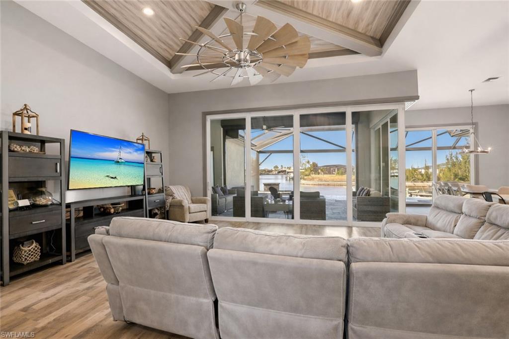 1616 Old Burnt Store Road North Cape Coral, FL 33993 - Photo 9 of 50 Living area with healthy amount of natural light, a covered lanai, light wood finished floors, recessed lighting, and a wooden ceiling with custom millwork exposed beams.