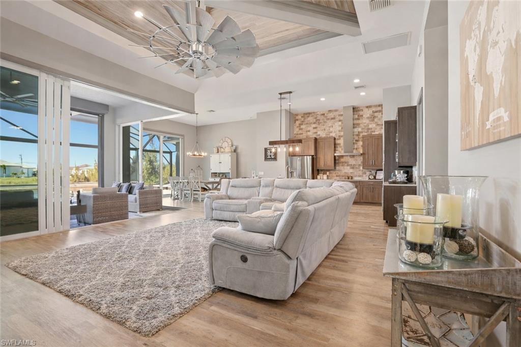 1616 Old Burnt Store Road North Cape Coral, FL 33993 - Photo 10 of 50 Living room featuring light wood finished floors, recessed lighting, ceiling fan, a towering ceiling, and a gorgeous fan to complement the decor. Notice the Zero Glass Sliding Door that opens up the outdoors to your indoor space.
