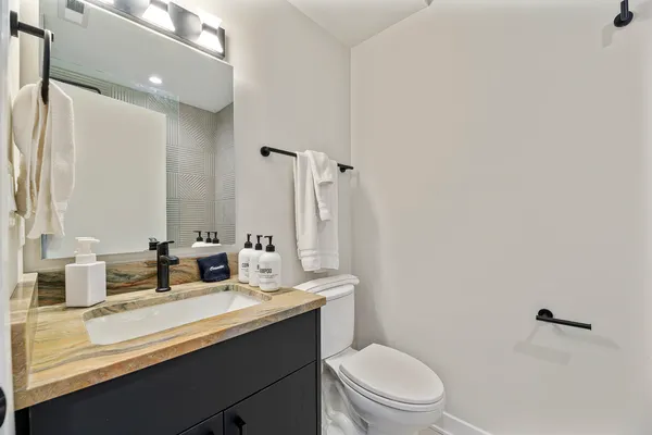 a bathroom with a double vanity sink toilet and mirror