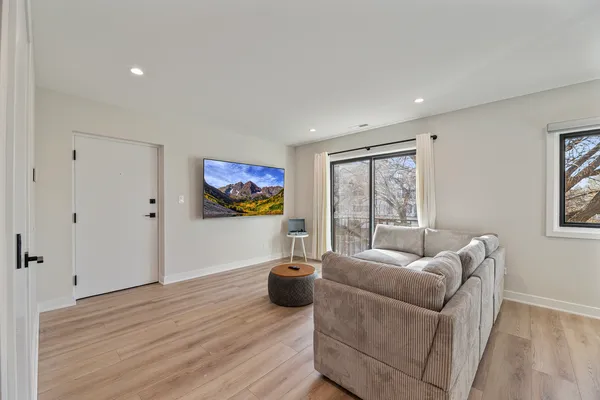a living room with furniture a flat screen tv and a window