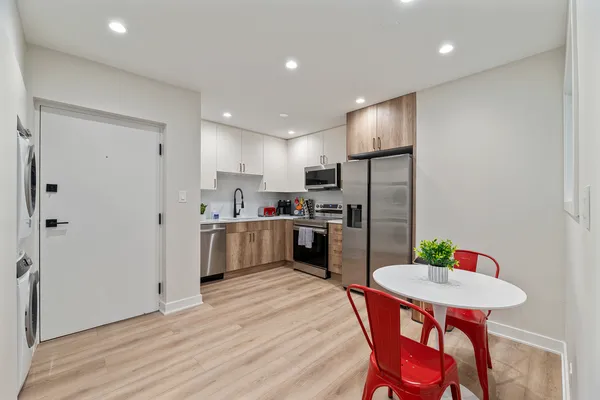 a kitchen with stainless steel appliances kitchen island granite countertop a refrigerator a stove a sink dishwasher with a dining table and chairs