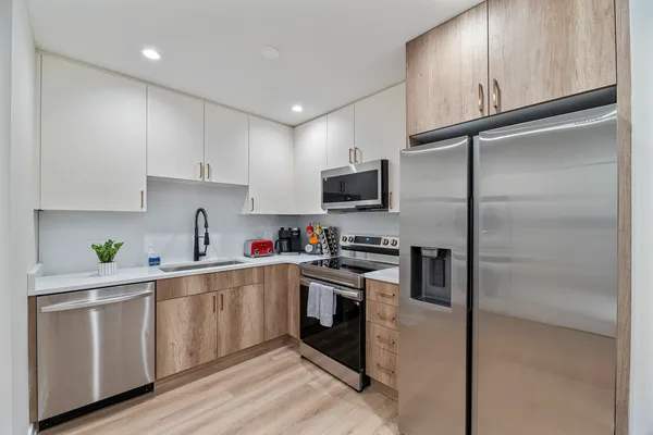 a kitchen with a refrigerator sink and white cabinets