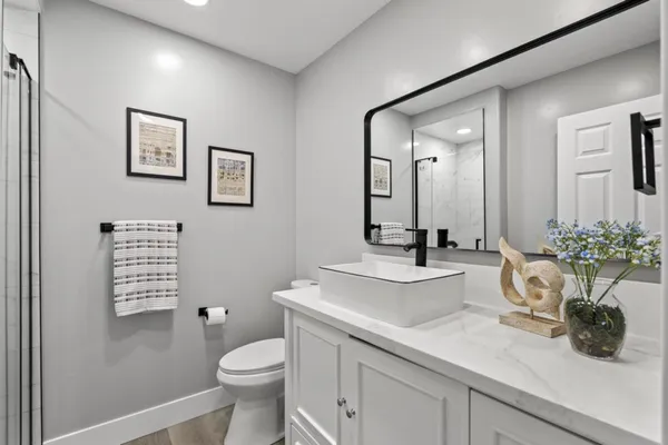 a bathroom with a sink a toilet a shower and a mirror