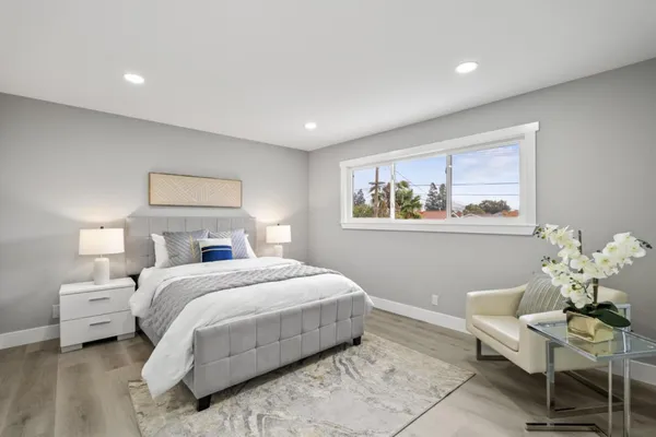 a spacious bedroom with a bed and a chandelier