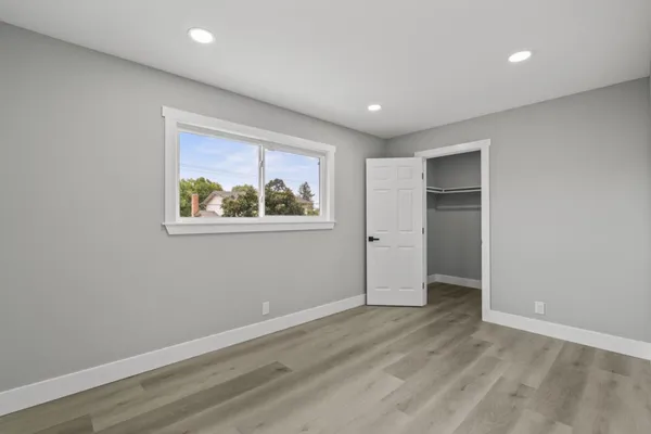 wooden floor in an empty room with a bathroom