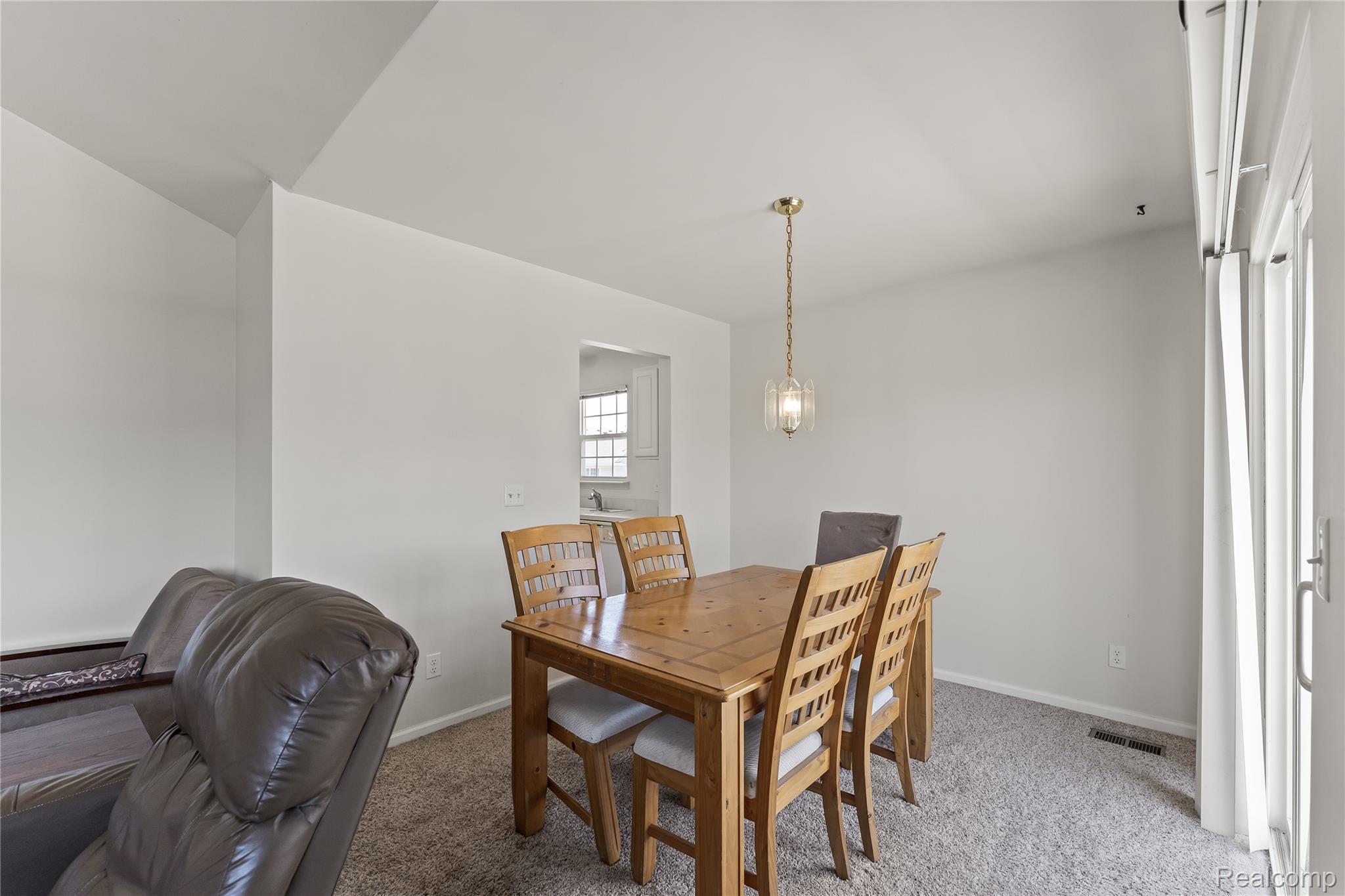 1861 Flagstone Circle Rochester, MI 48307 - Photo 9 of 21 Dining area featuring a brass-finish pendant light fixture and carpeted flooring