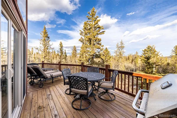 a view of a balcony with wooden floor and outdoor seating
