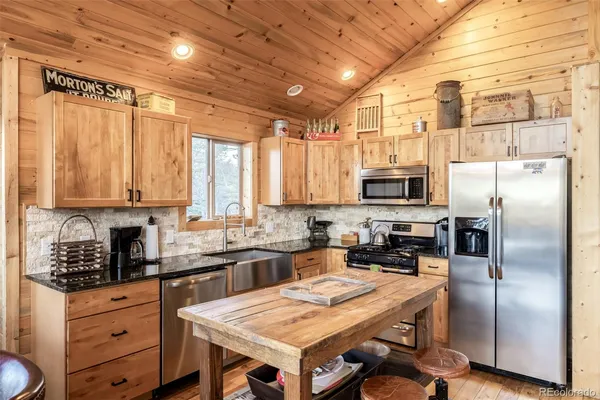 a kitchen with a refrigerator a sink dishwasher a stove and a microwave oven with cabinets