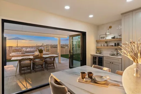 a living room with furniture kitchen view and large windows