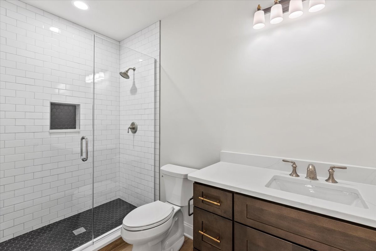 1 West Penny Road South Barrington, IL 60010 - Photo 28 of 30 a bathroom with a granite countertop sink a toilet a mirror and shower