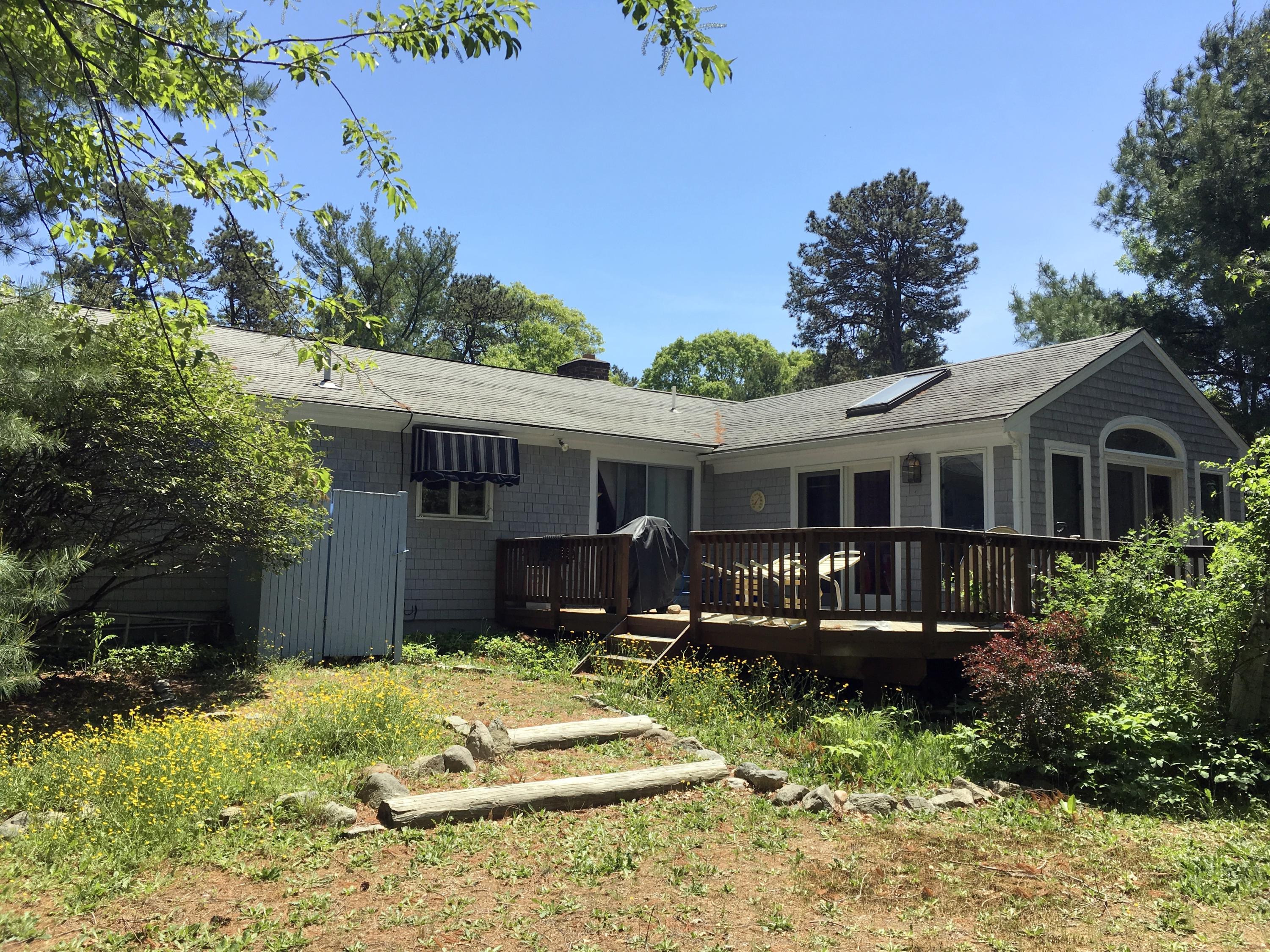 88 Cedric Road Centerville, MA 02632 - Photo 2 of 25 a front view of a house with a yard table and chairs