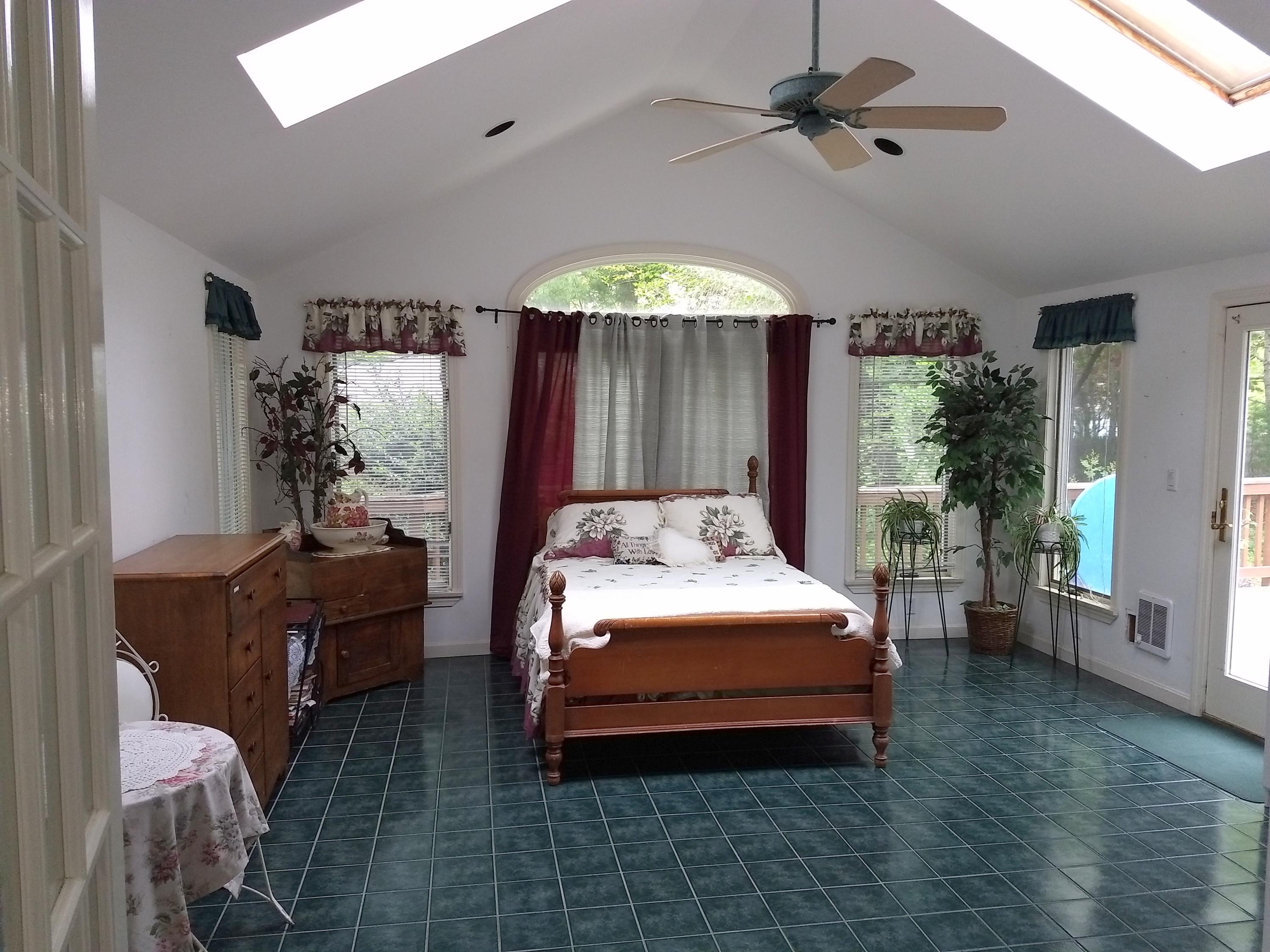 88 Cedric Road Centerville, MA 02632 - Photo 24 of 25 a bedroom with a bed dresser and a chandelier