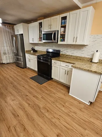 a kitchen with stainless steel appliances granite countertop a stove a sink and a microwave